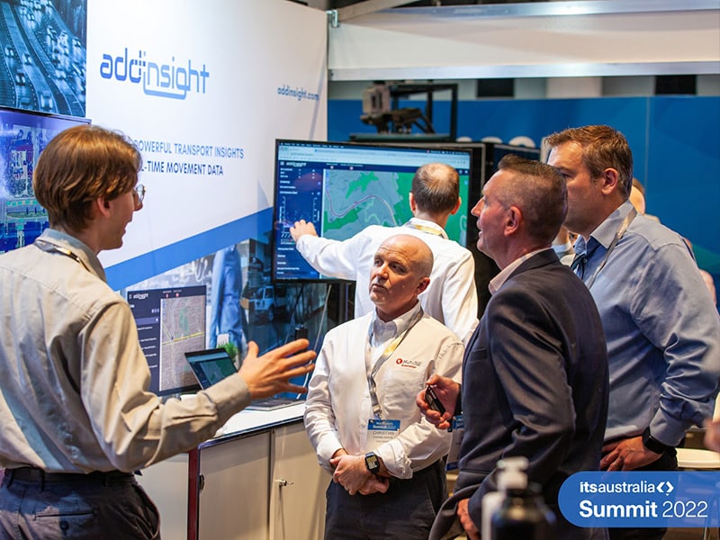 The Addinsight stand at Summit 2022 with the software on display and team members having discussions with clients